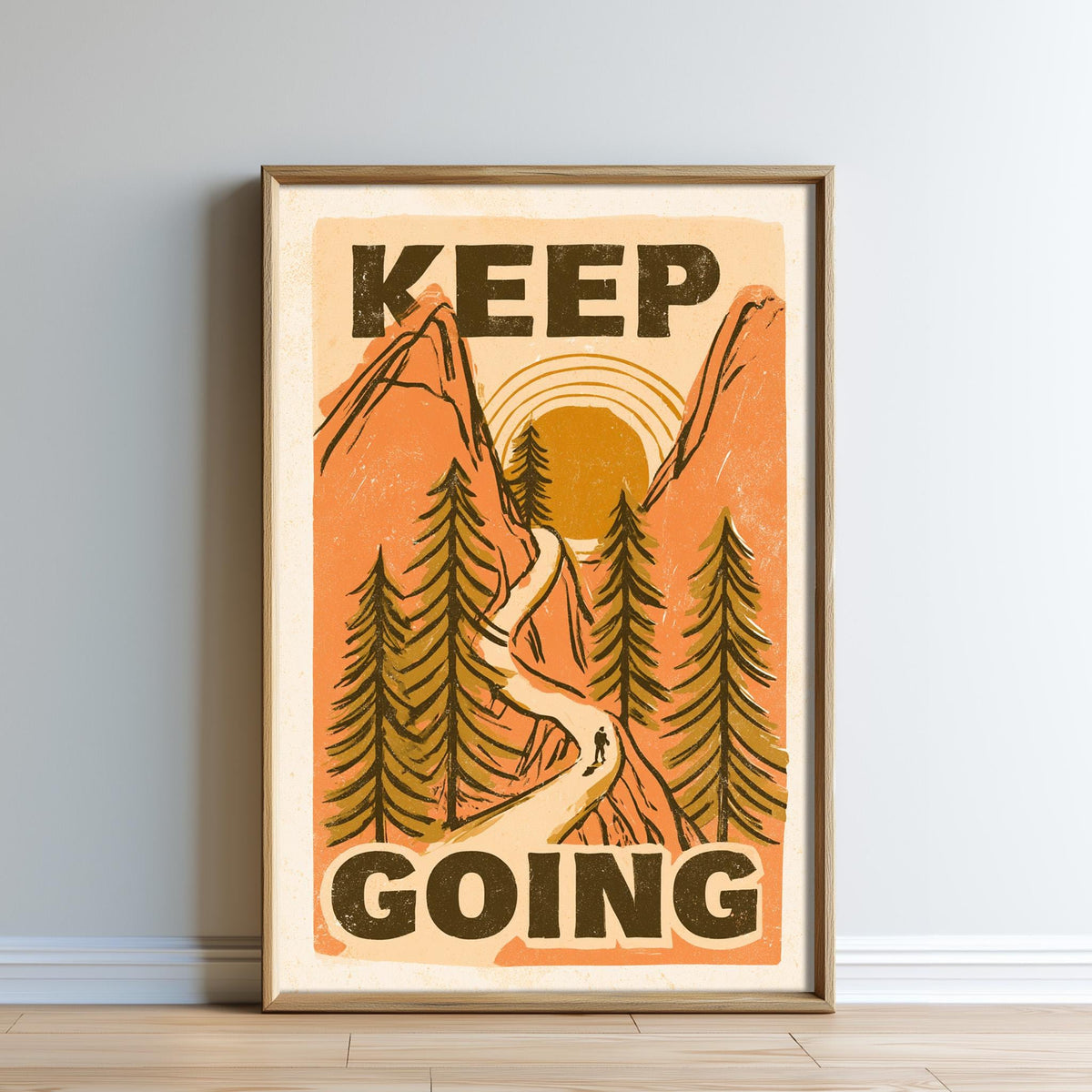 The image is a framed poster with a mountain landscape and a person walking along a path. The poster has the text "KEEP GOING" prominently displayed.