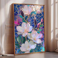 A framed stained glass artwork depicting a vibrant floral arrangement with pink and white flowers, surrounded by blue and green leaves, is displayed on a wall in a room with a window.