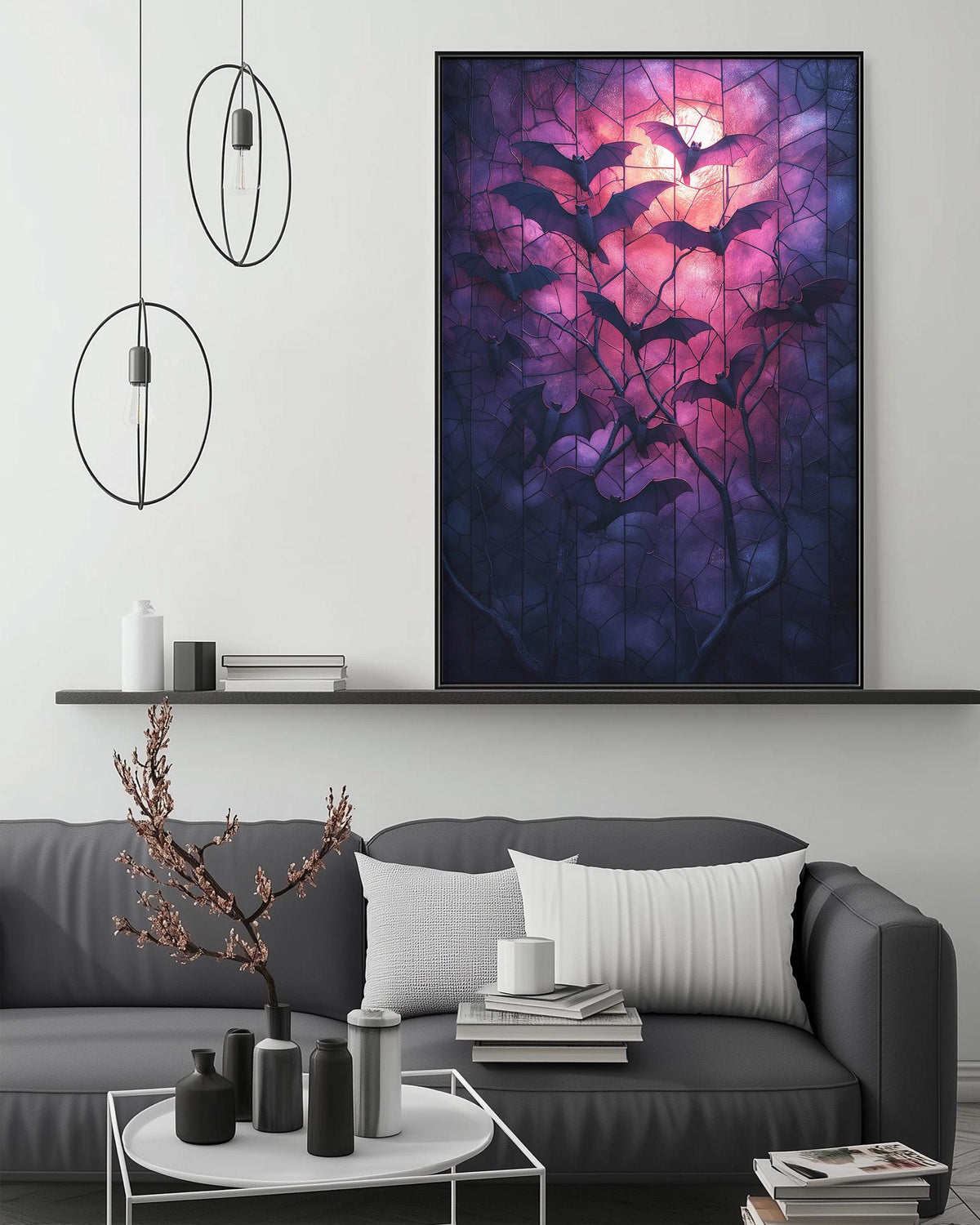 a living room with a gray sofa, a coffee table, and a large framed artwork depicting bats silhouetted against a night sky with a glowing moon.