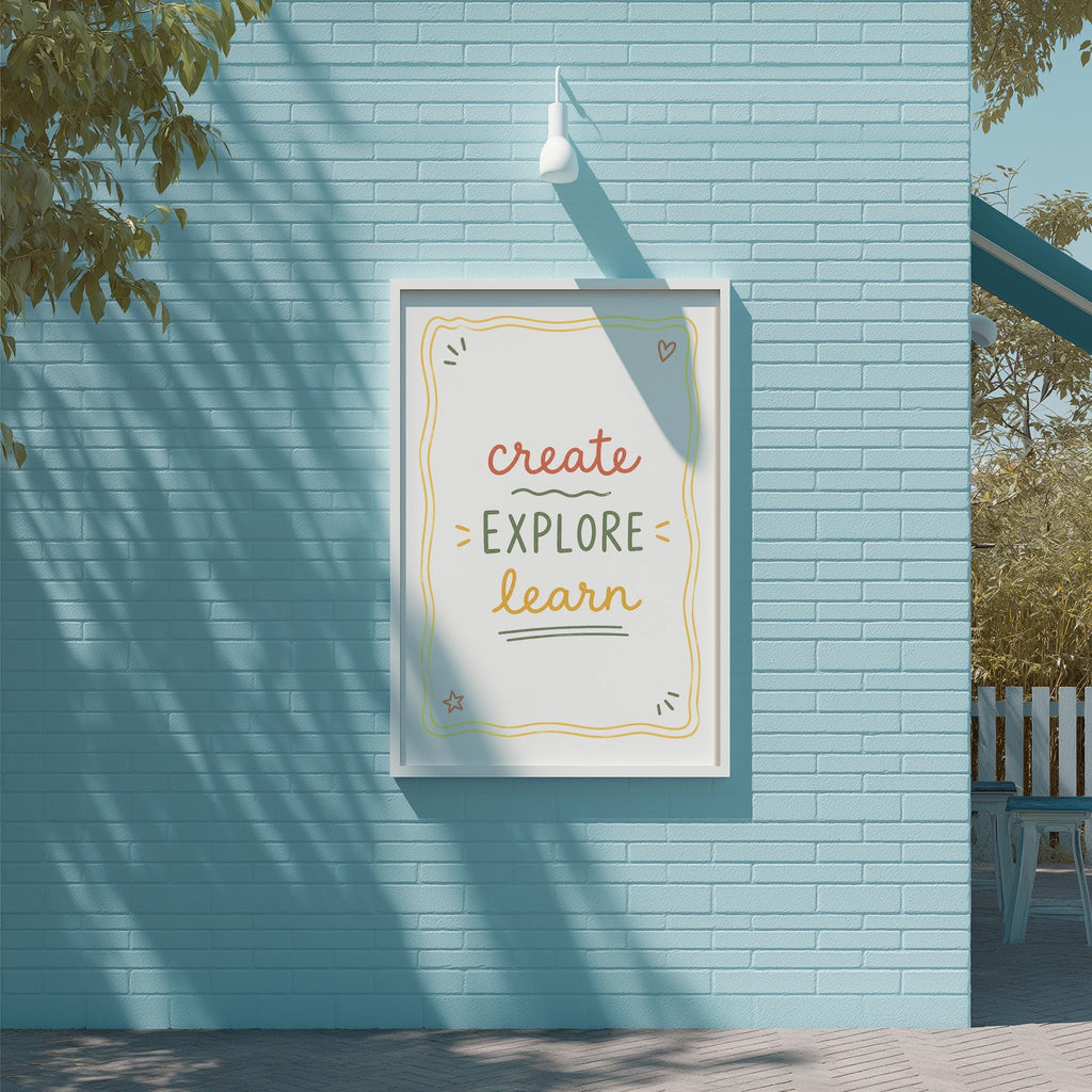 A framed poster with the text "CREATE EXPLORE LEARN" is displayed on a blue brick wall, with a tree and a white light fixture above it.