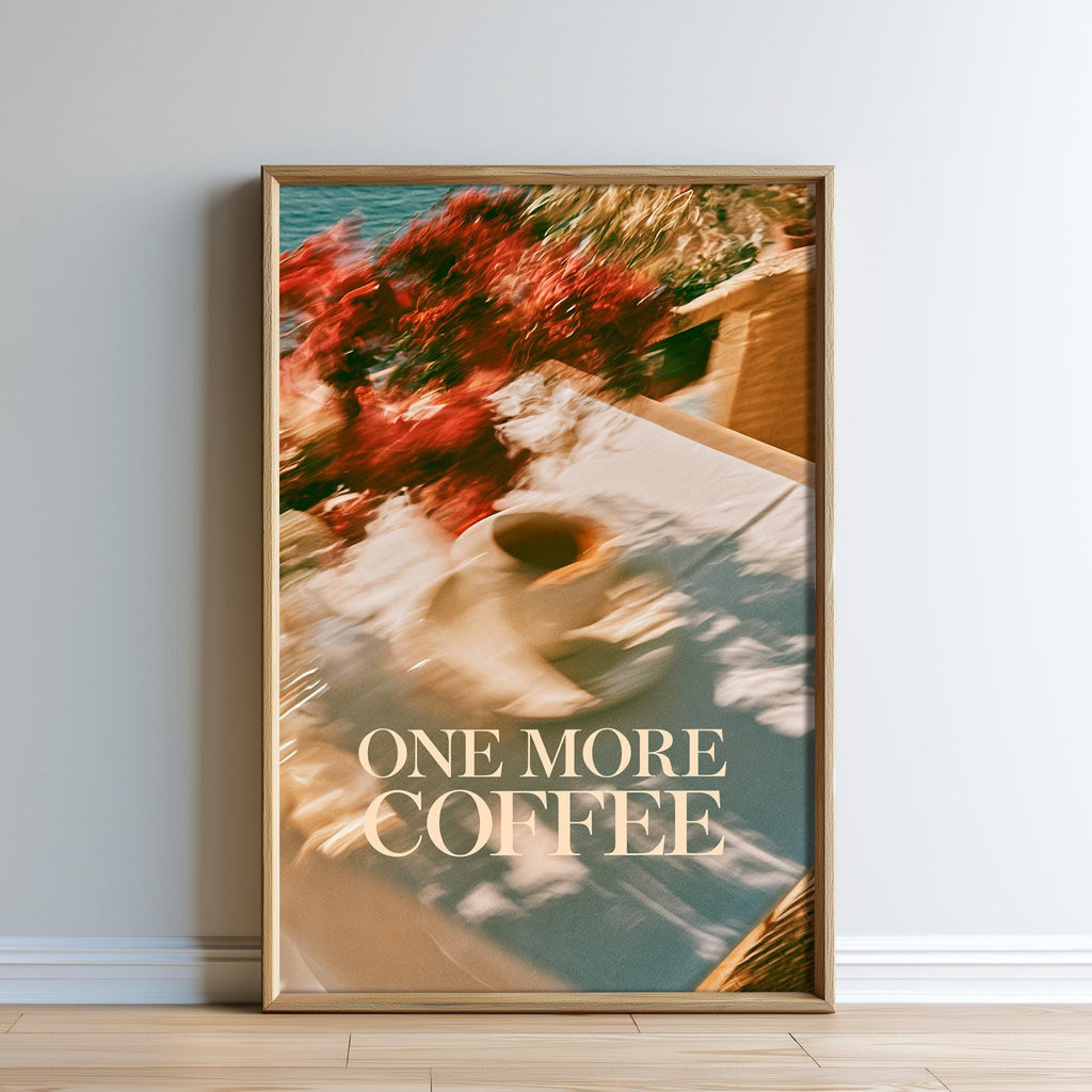 The image is a framed poster with a blurred background featuring a cup of coffee and flowers. The text on the poster says "ONE MORE COFFEE".