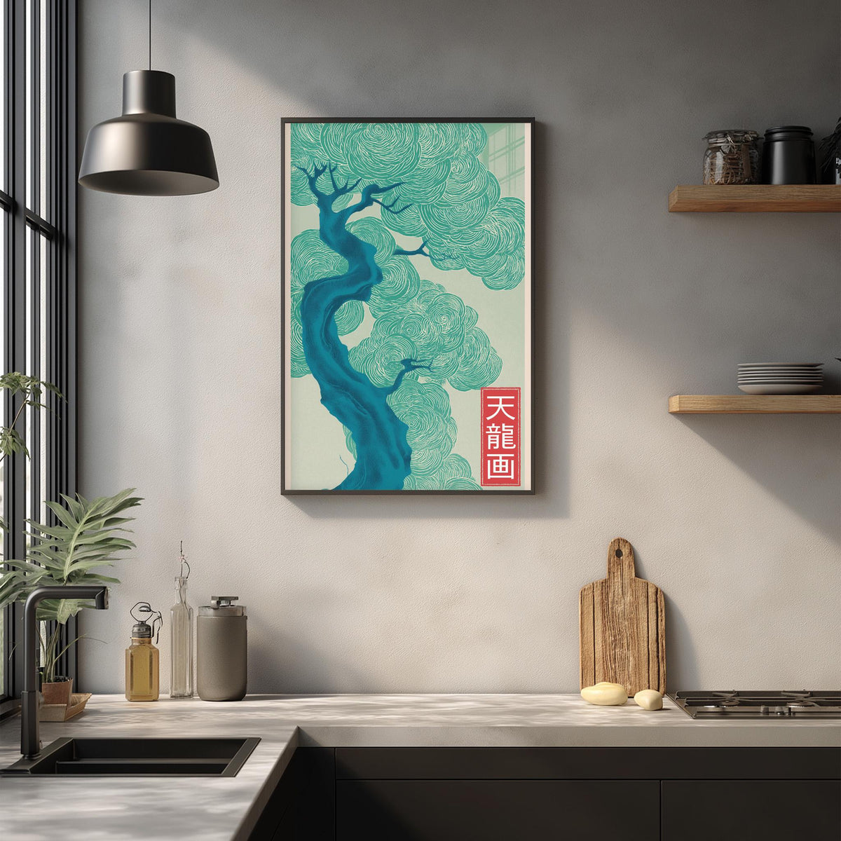 a kitchen counter with a framed poster of a tree with blue and green hues hanging above it. The poster has a red Chinese character on it. The kitchen counter also has various items such as a cutting board, a bottle, and a plant.