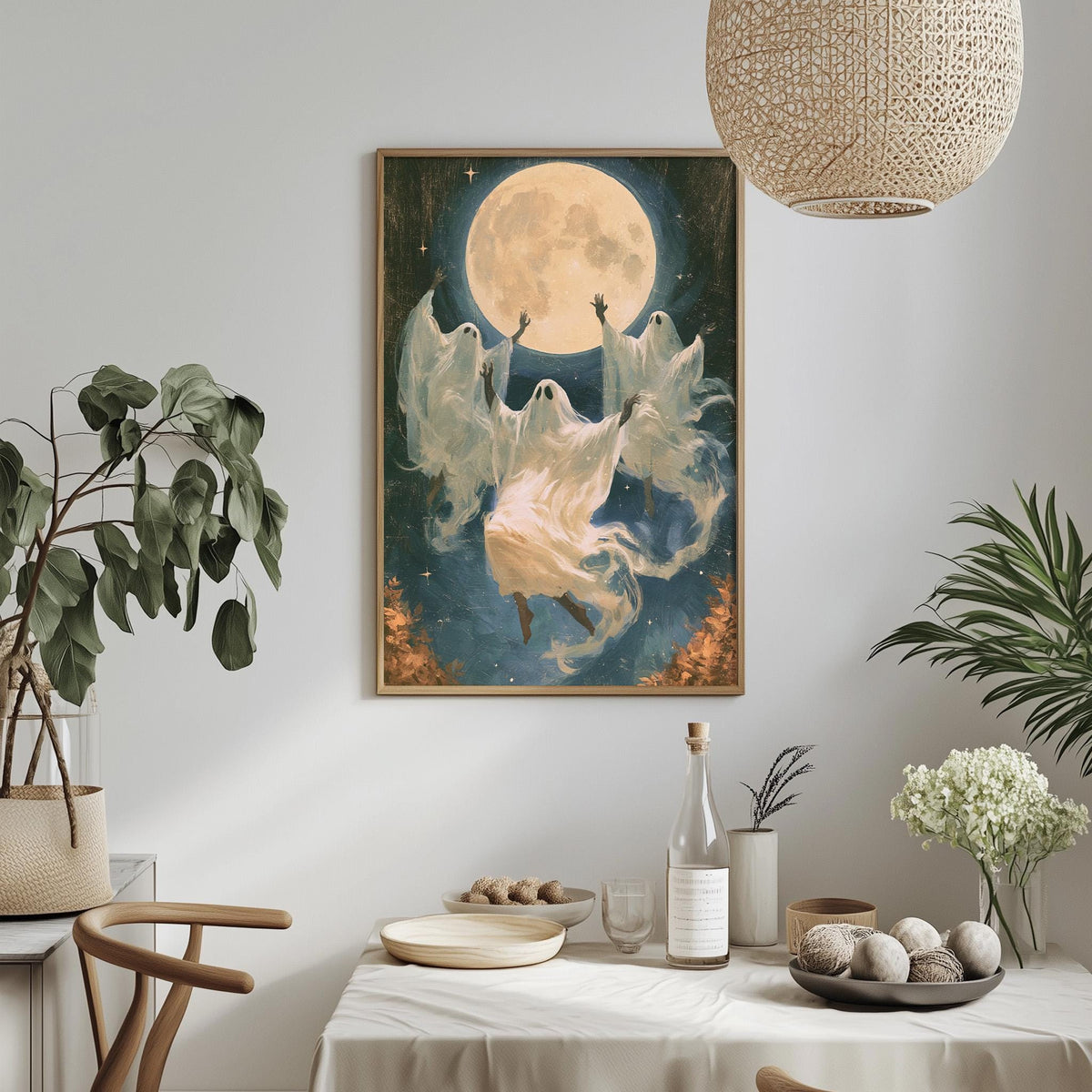 a framed painting of a ghost floating in the air, surrounded by a large moon and stars, with a table set with plates, bowls, and a bottle of wine in the foreground.