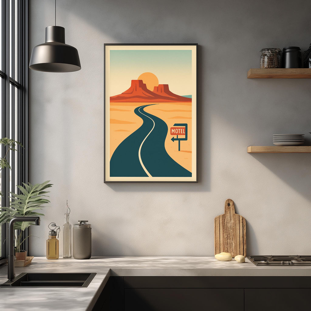 a framed poster of a desert road with a motel sign, hanging on a wall above a kitchen counter with various kitchen items and a potted plant.