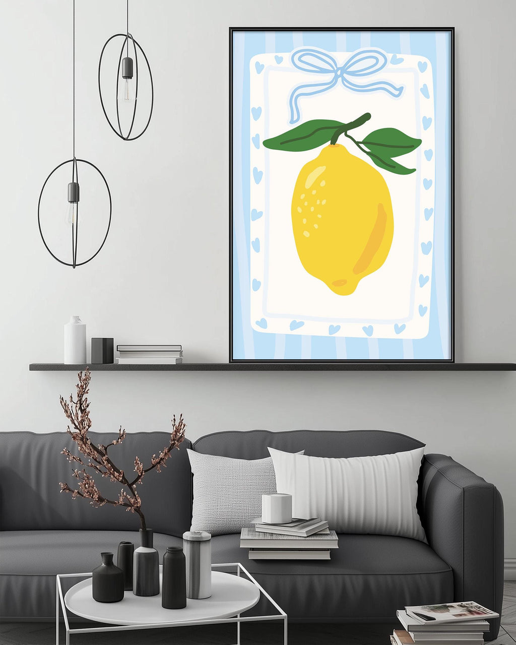a modern living room with a gray sofa, a coffee table, and a framed artwork of a lemon on the wall.