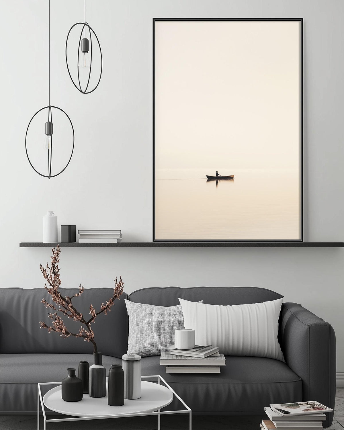 a serene living room with a gray sofa, a coffee table, and a large framed picture of a boat on the wall. The room has a minimalist and modern design, with a black and white color scheme and a few decorative elements such as a potted plant and a vase.