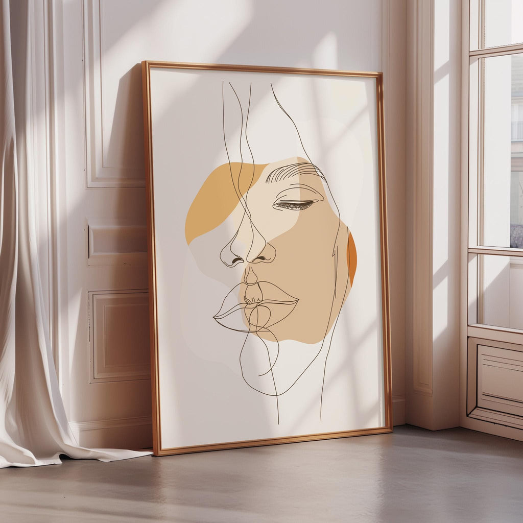 a framed abstract drawing of a woman's face, which is displayed in a corner of a room with sunlight streaming in from a window.