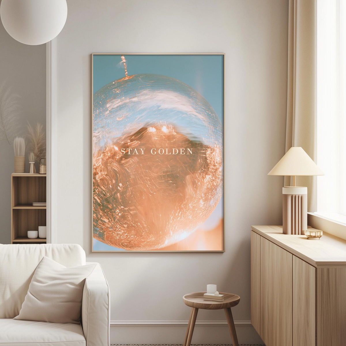 a large framed poster with the text "STAY GOLDEN" on it, hanging on a wall in a living room setting.