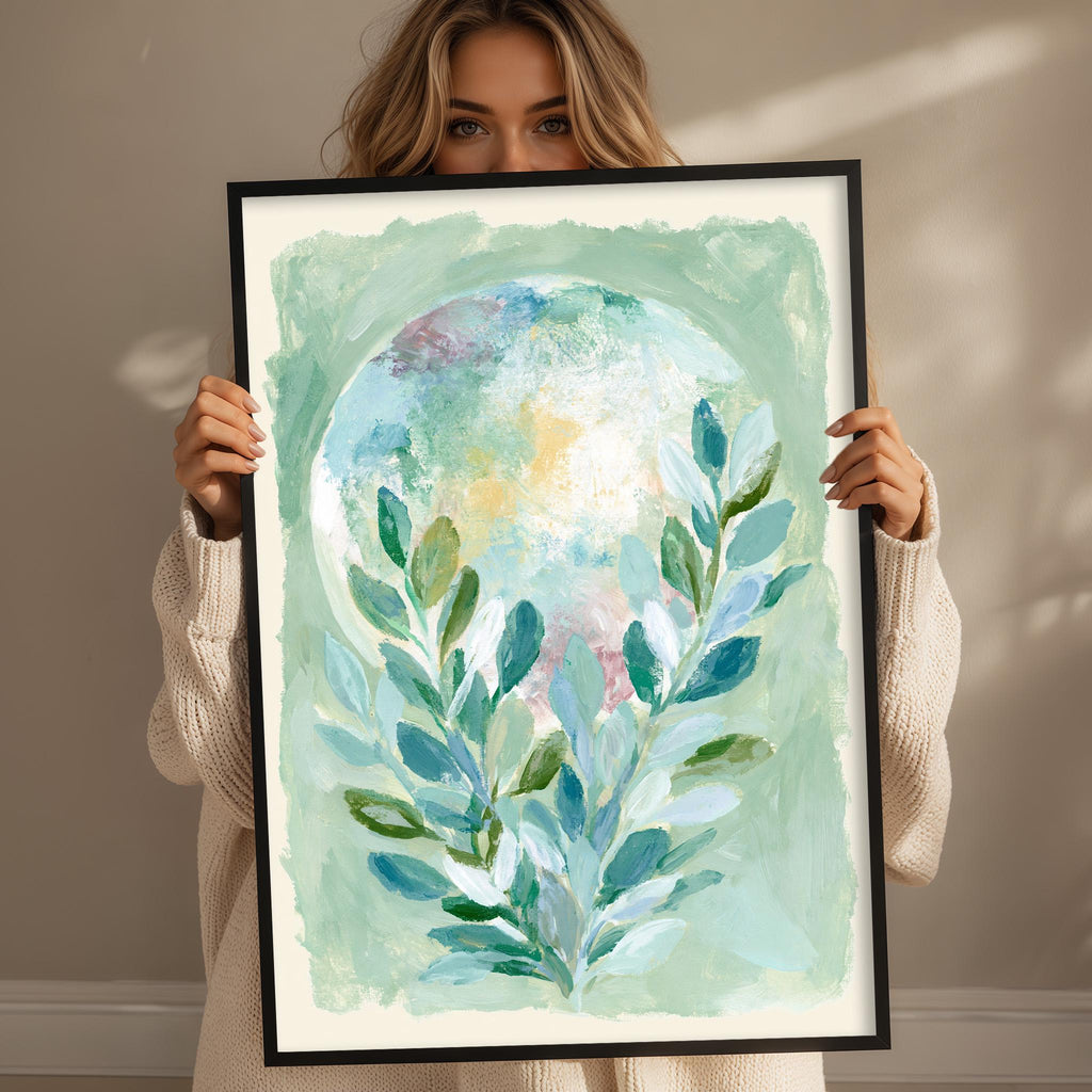 A woman holds a framed painting of a leafy green plant in front of her face.