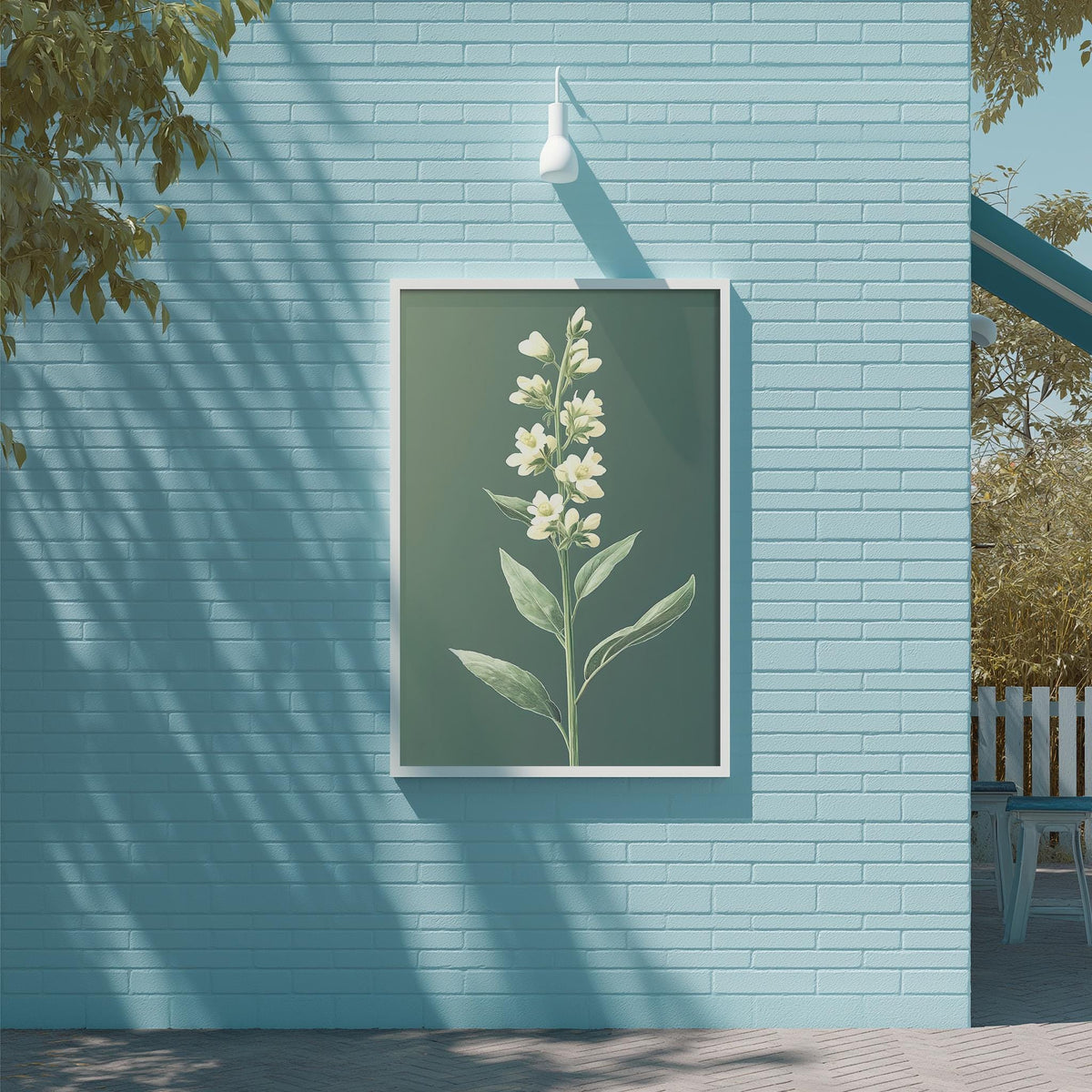 a framed picture of a white flower on a blue brick wall, with a white light fixture hanging above it.