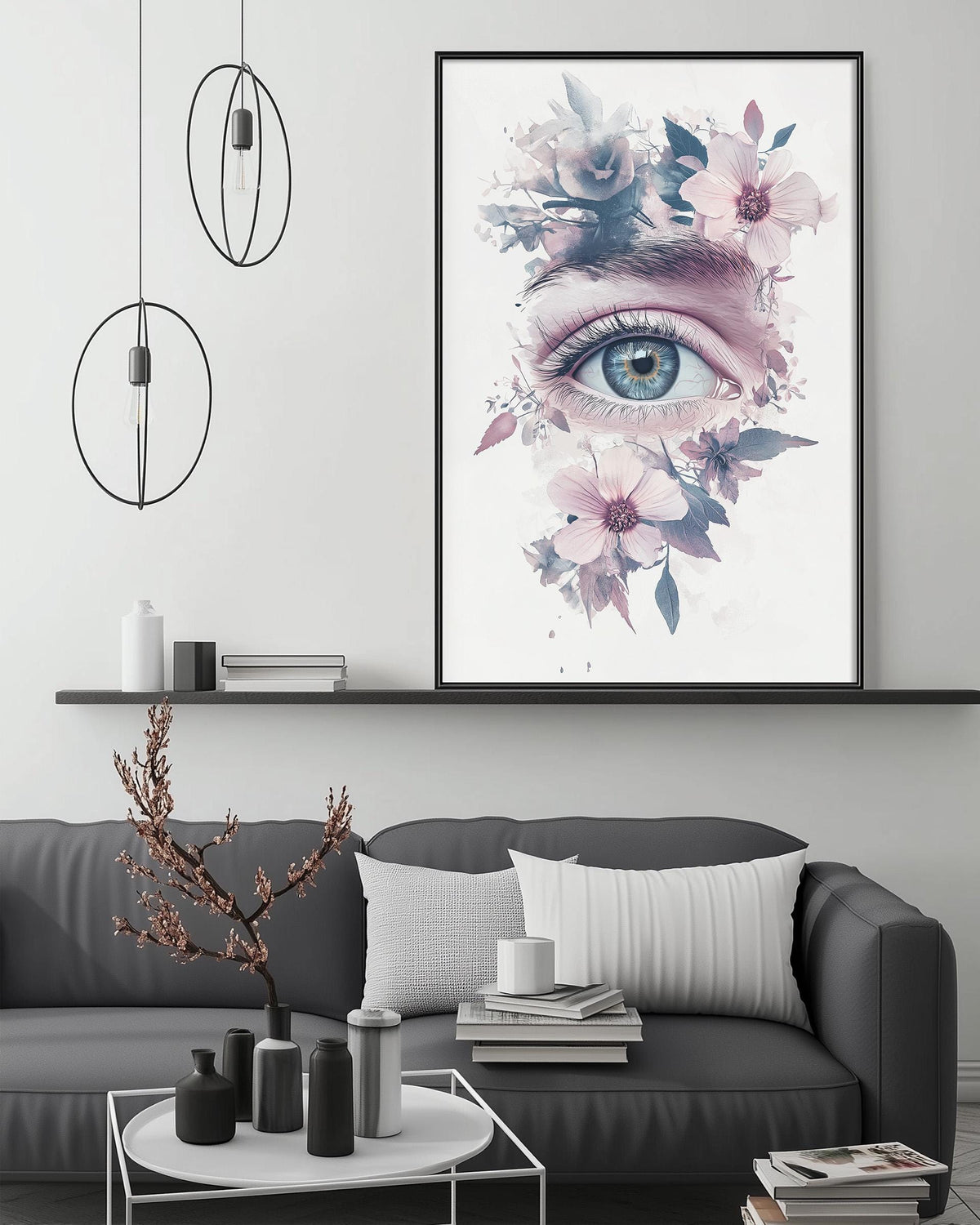 a large framed artwork depicting a close-up of an eye surrounded by a floral design, hanging above a gray couch in a living room setting.