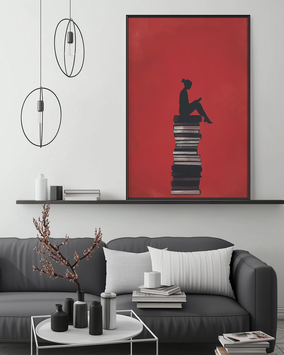 a cozy living room with a gray couch, a coffee table, and a large framed artwork depicting a person sitting on a stack of books.