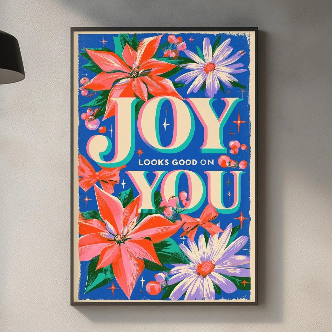a kitchen counter with a framed poster of a colorful floral design hanging above it. The poster has the text "JOY YOU" written on it, and there are various kitchen items, such as a cutting board, bottles, and a sink, visible on the counter.
