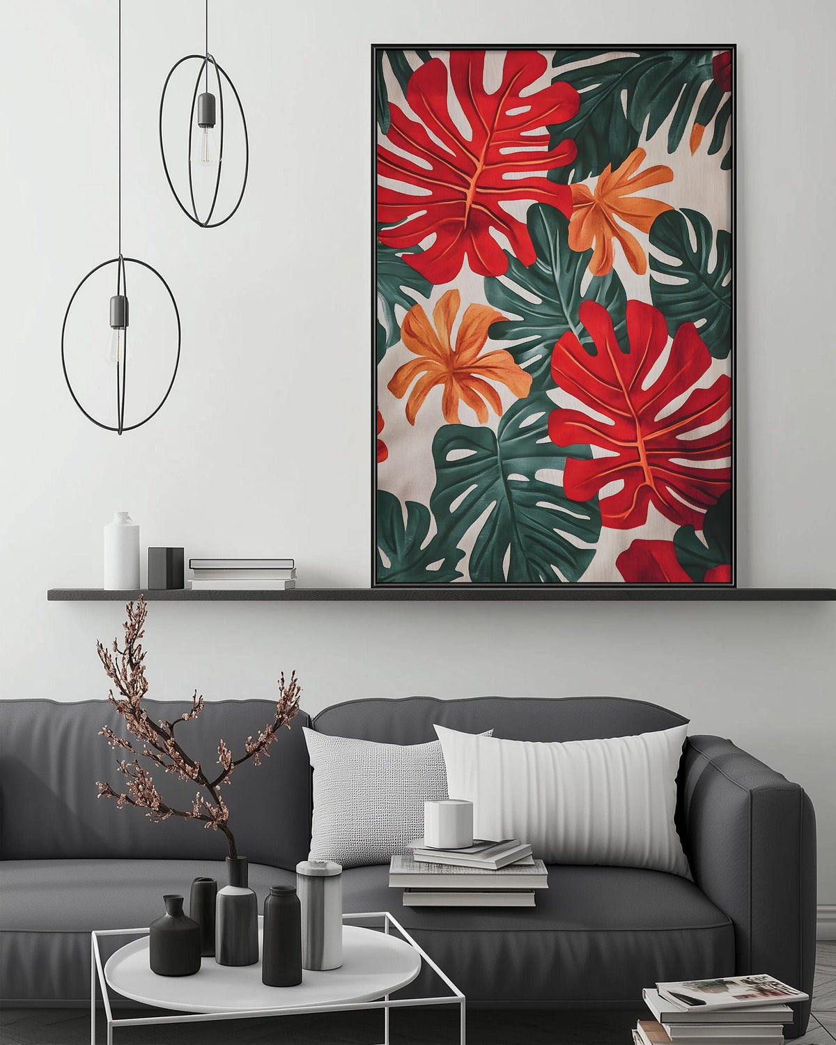 a modern living room with a gray sofa, a coffee table, and a large framed print of tropical leaves on the wall above the sofa.