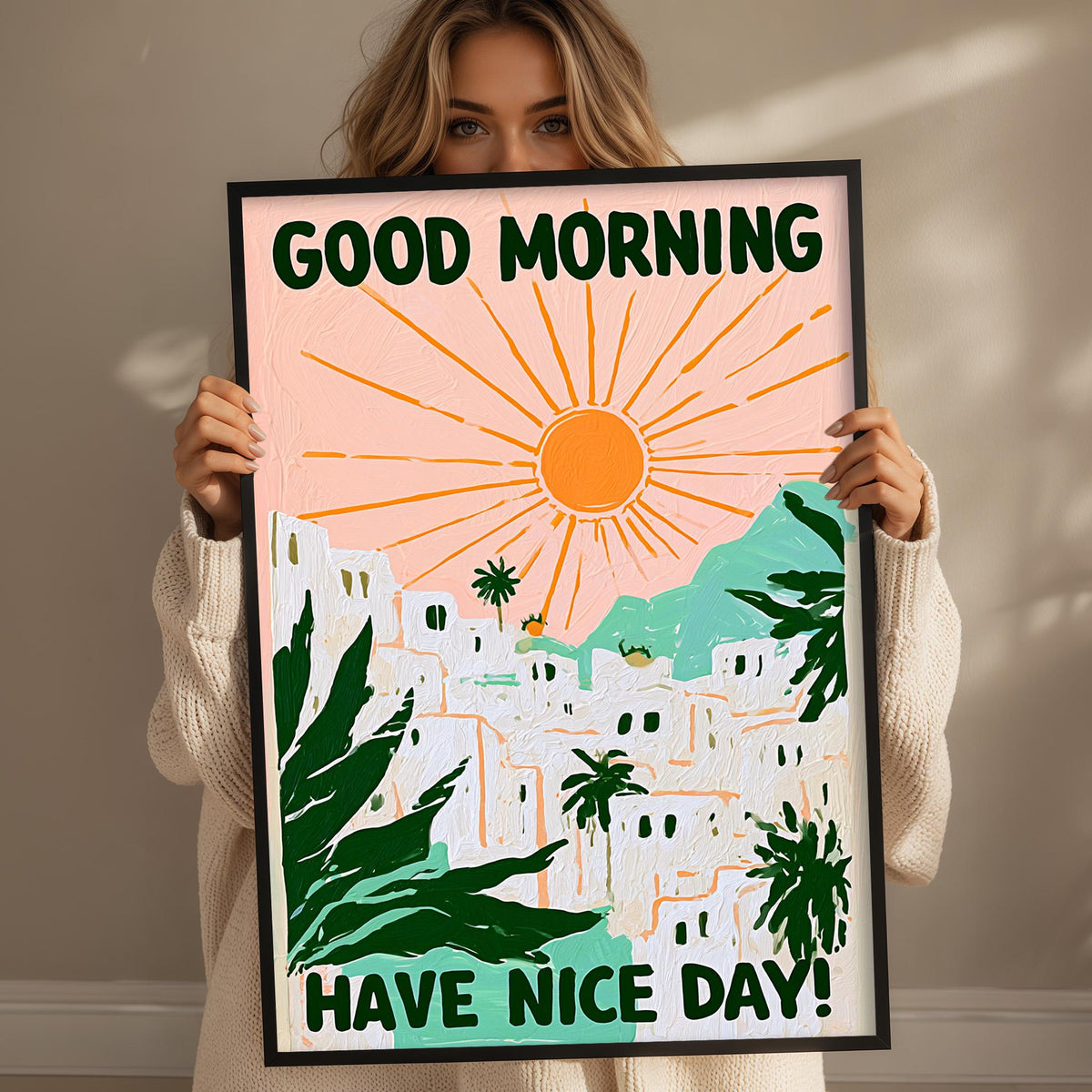 A woman holding a framed poster with a colorful illustration of a tropical landscape and the text "GOOD MORNING HAVE NICE DAY!"