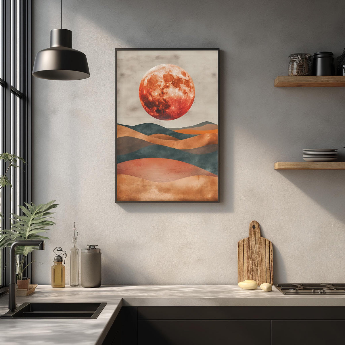 a kitchen counter with a framed painting of a red moon above it, along with various kitchen items such as a cutting board, a bottle, and a vase.