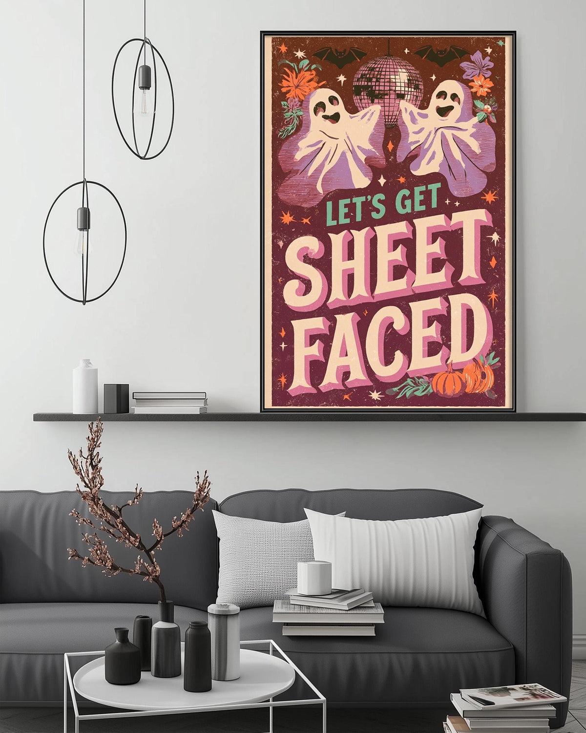a poster with a Halloween theme, hanging on a wall above a gray couch with a coffee table in front of it.