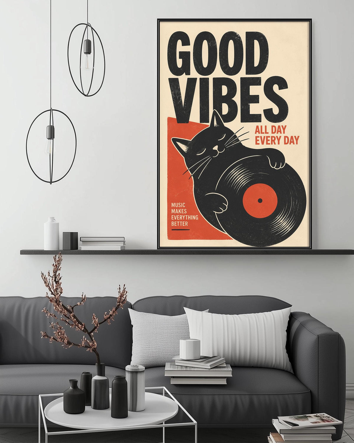 a poster with the text "Good Vibes" and an illustration of a cat holding a record album. The poster is displayed on a wall above a gray couch in a living room setting.