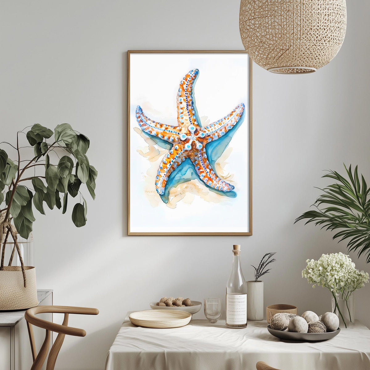 a framed watercolor painting of a starfish hanging on a wall above a dining table with various decorative items and plants.