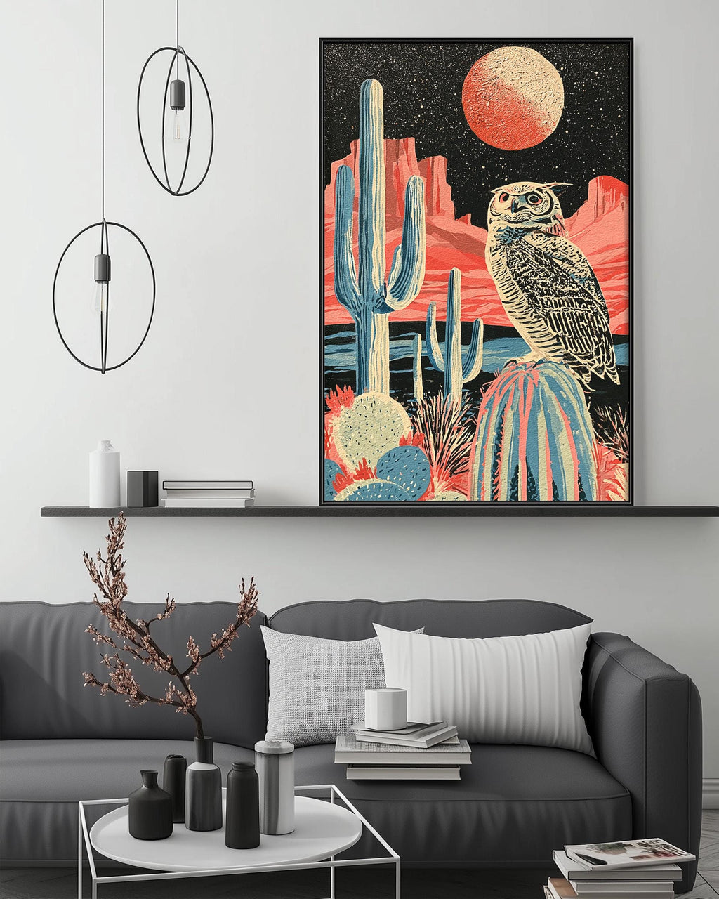 a modern living room with a gray sofa, a coffee table, and a large framed artwork depicting a desert landscape with a cactus and an owl.