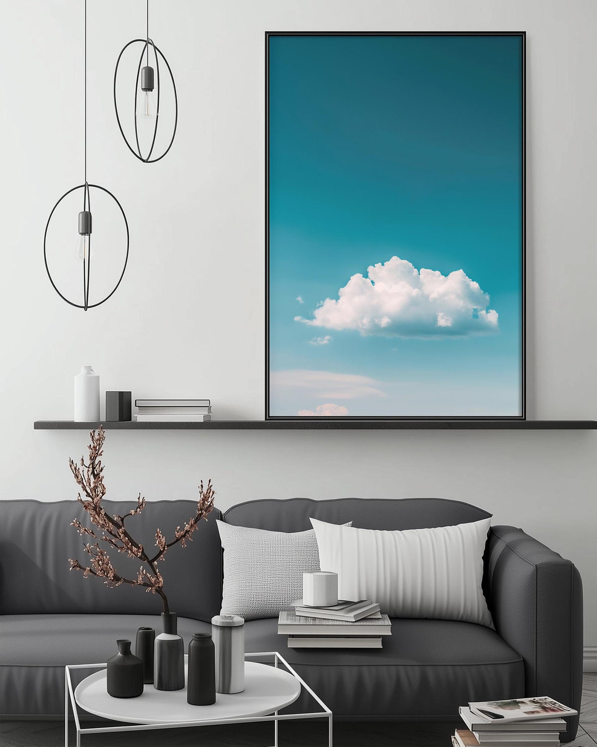 a modern living room with a gray sofa, a coffee table, and a large framed picture of a blue sky with a fluffy white cloud hanging on the wall above the sofa.
