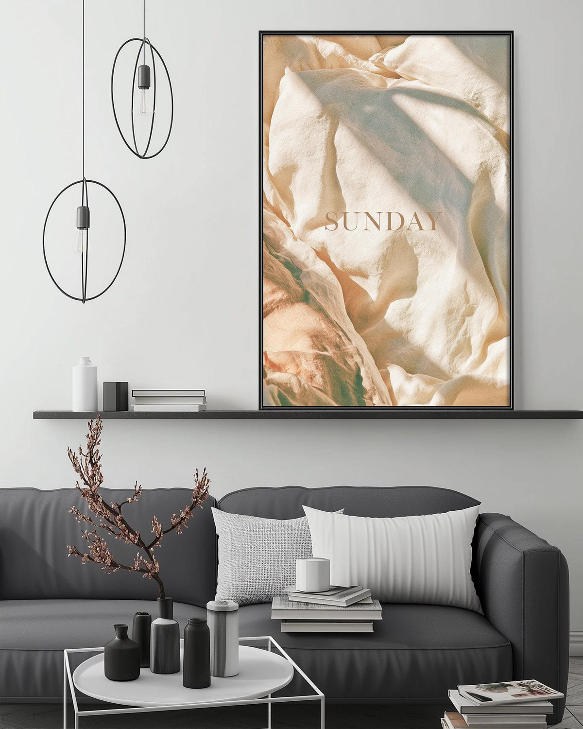 a modern living room with a gray sofa, a coffee table, and a large framed poster of a textured fabric hanging on the wall above the sofa.