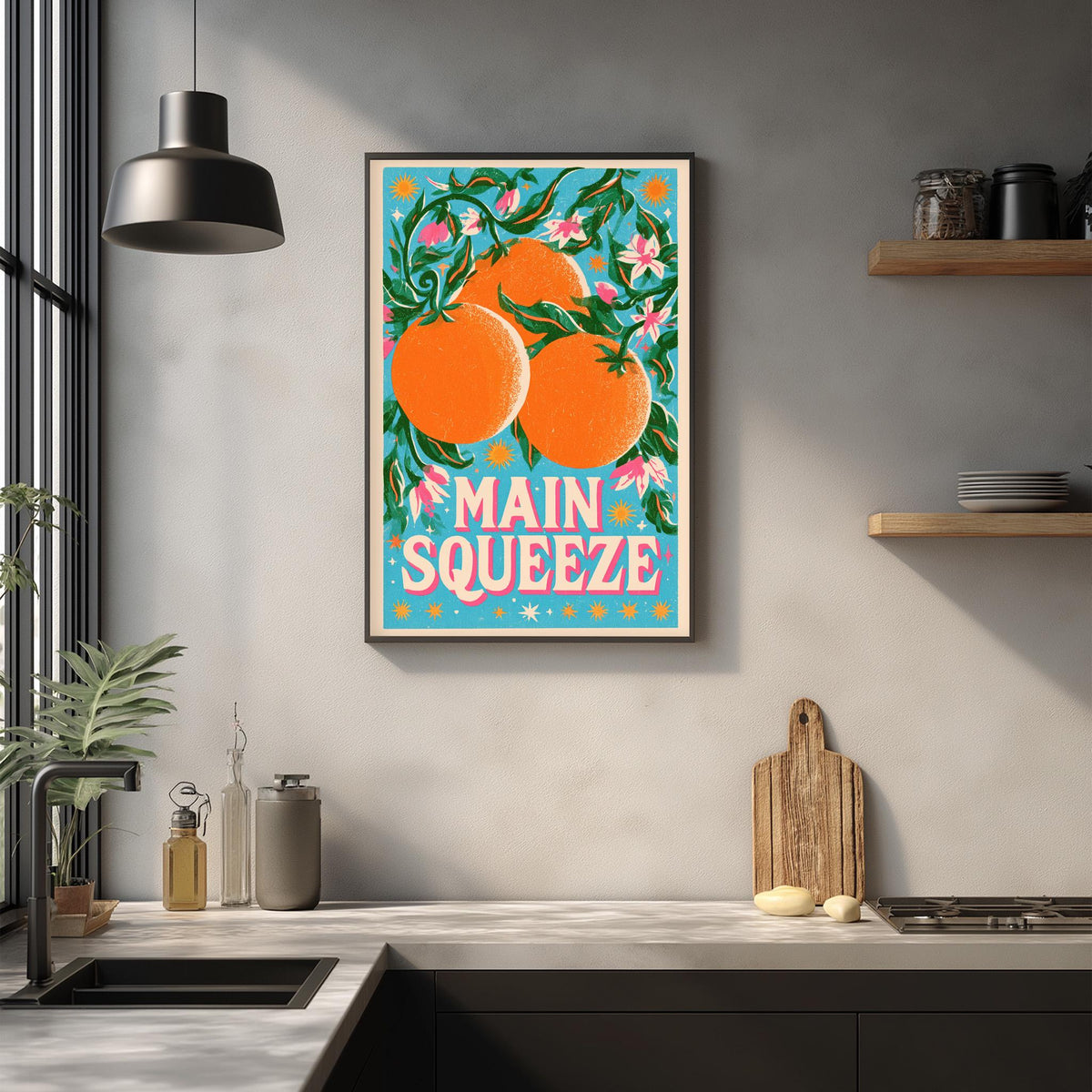 a kitchen counter with a framed poster of oranges hanging on the wall above it.