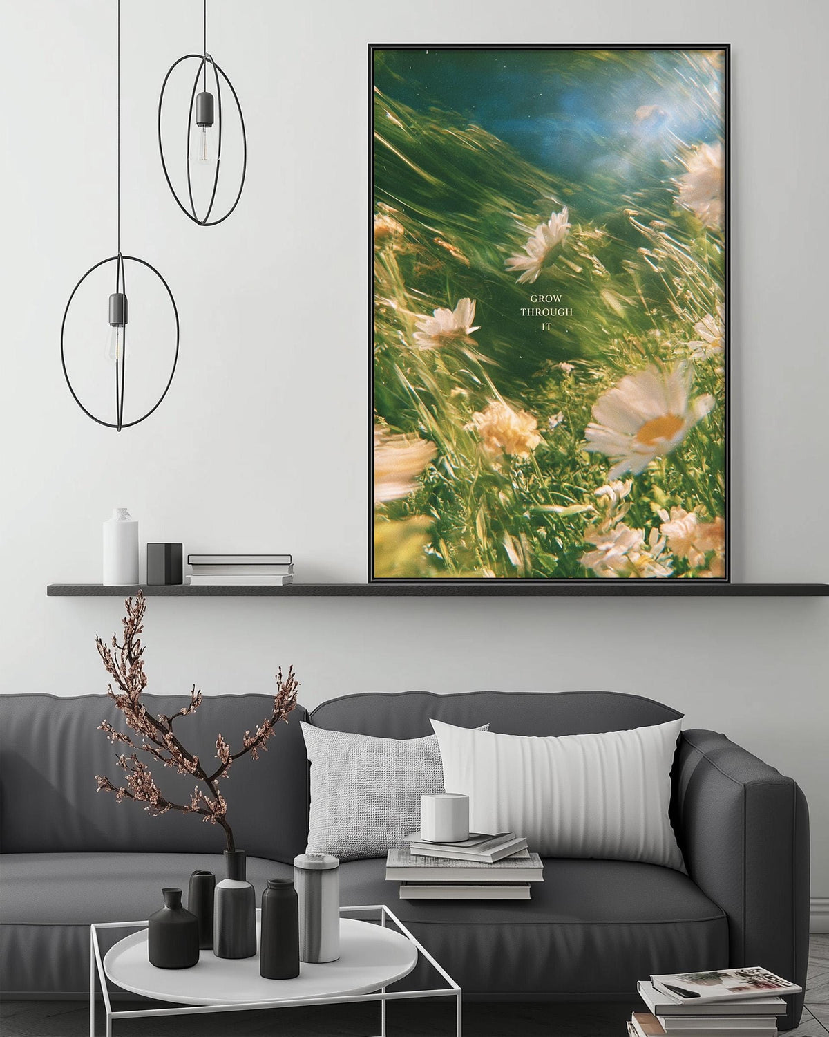 a modern living room with a gray sofa, a coffee table, and a large framed print of a floral image hanging on the wall above the sofa.