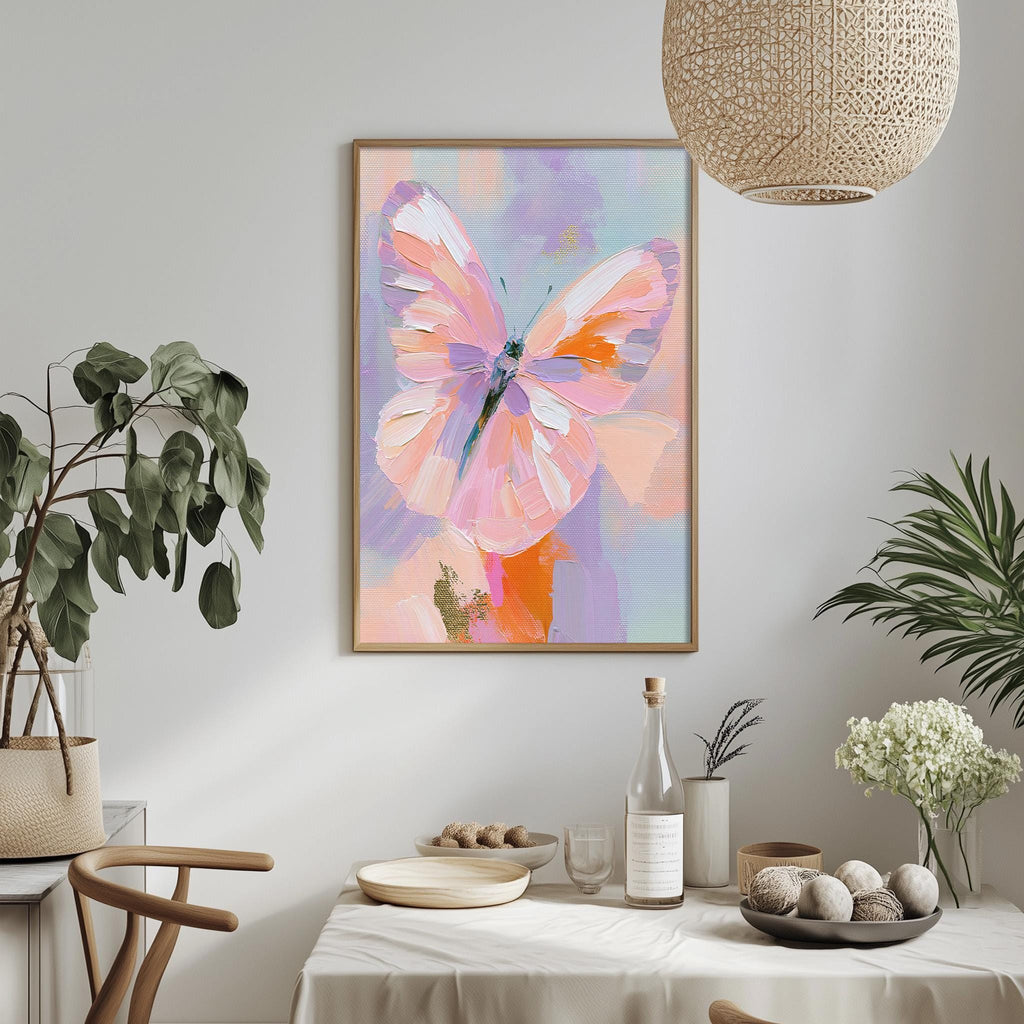 a dining table with a white tablecloth, a vase of white flowers, a bottle, and a bowl of fruit. Above the table, there is a framed painting of a butterfly in pink and orange hues.