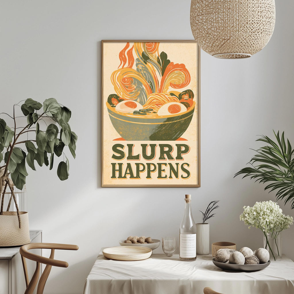 a framed poster with a vibrant illustration of a bowl of noodles and the text "SLURP HAPPENS" hanging on a wall above a dining table with various items on it.