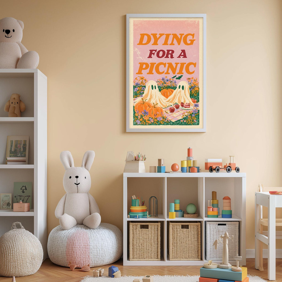 A child's bedroom with a stuffed rabbit, a bookshelf, and a framed poster on the wall. The poster features a cartoon illustration of a picnic scene with ghostly figures and pumpkins.