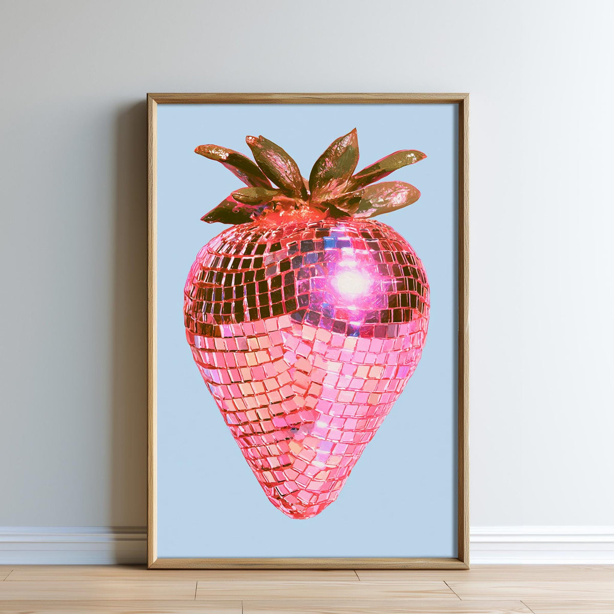 A framed image of a pink disco ball with a strawberry design, set against a light blue background.
