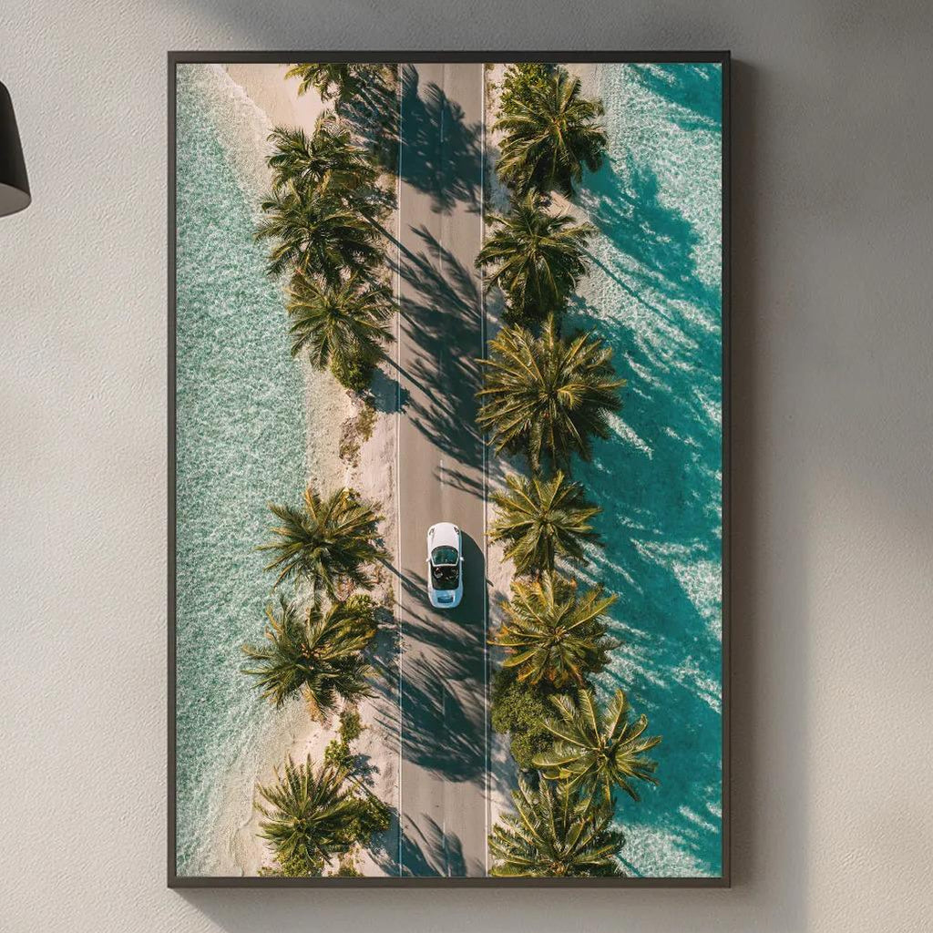 a kitchen counter with various kitchen items, including a cutting board, a bottle, and a vase. Above the counter, there is a framed picture of a tropical beach with palm trees and a car driving down a road.