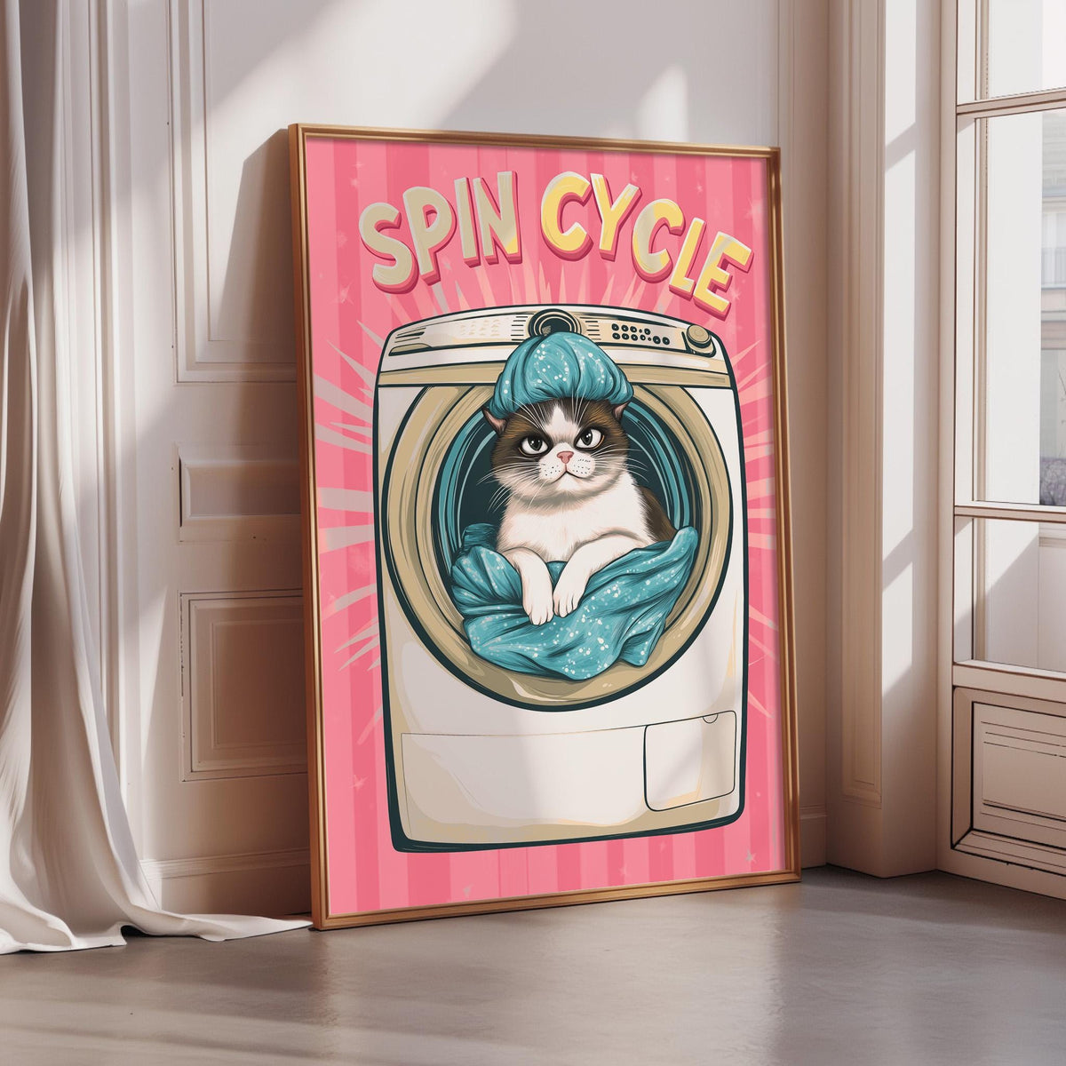 A framed illustration of a cat sitting inside a washing machine, with the text "SPIN CYCLE" above it.
