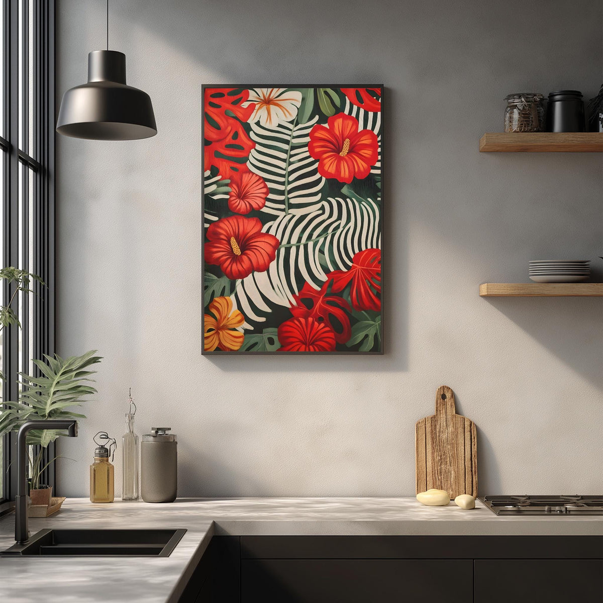 a kitchen counter with a framed print of a tropical flower design hanging above it. The print has a vibrant mix of red, orange, and green hues, creating a lively and colorful atmosphere. The kitchen counter also has various items such as a cutting board, a soap dispenser, and a bottle, adding to the overall aesthetic of the space.