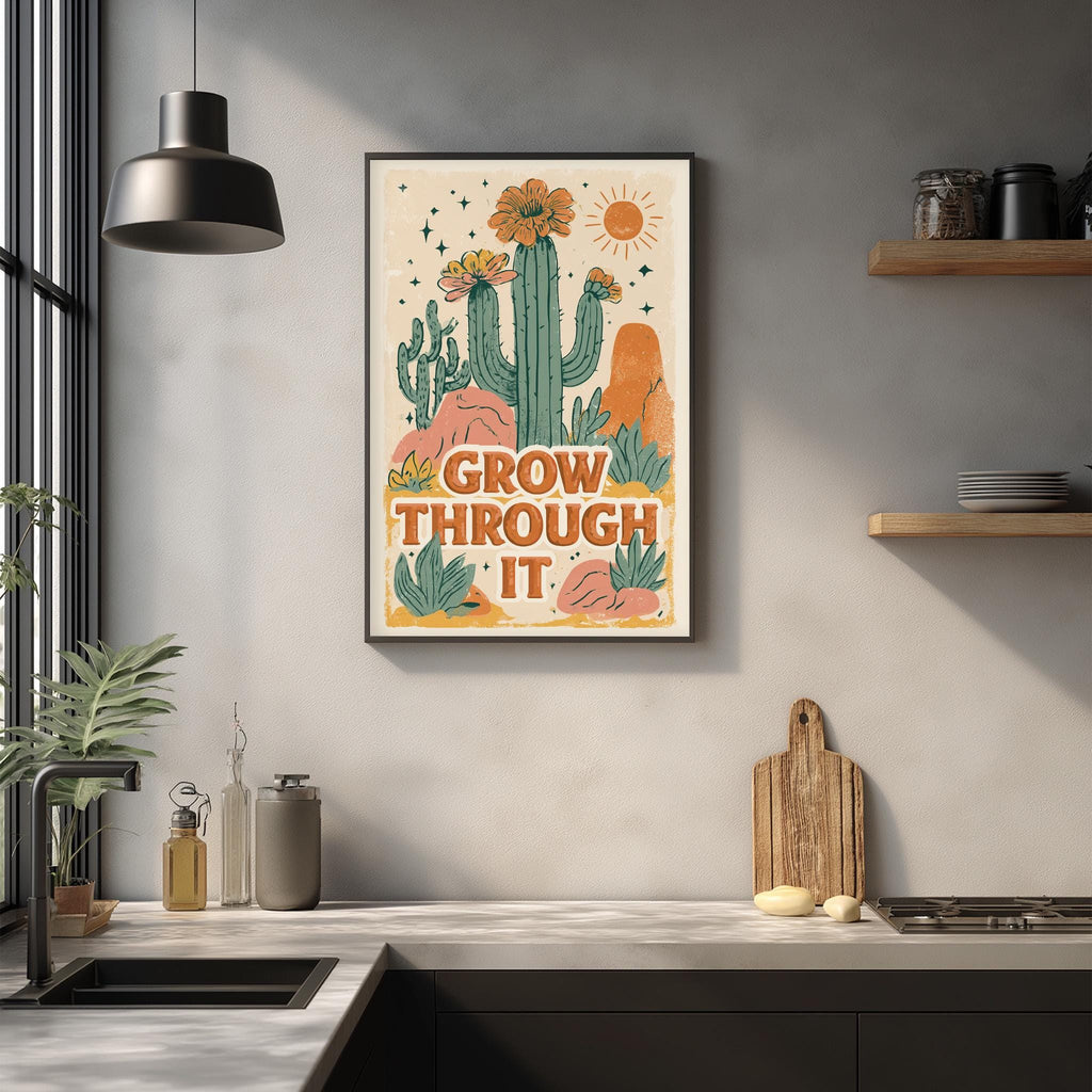 a framed poster with a desert-themed illustration, hanging on a wall above a kitchen counter.