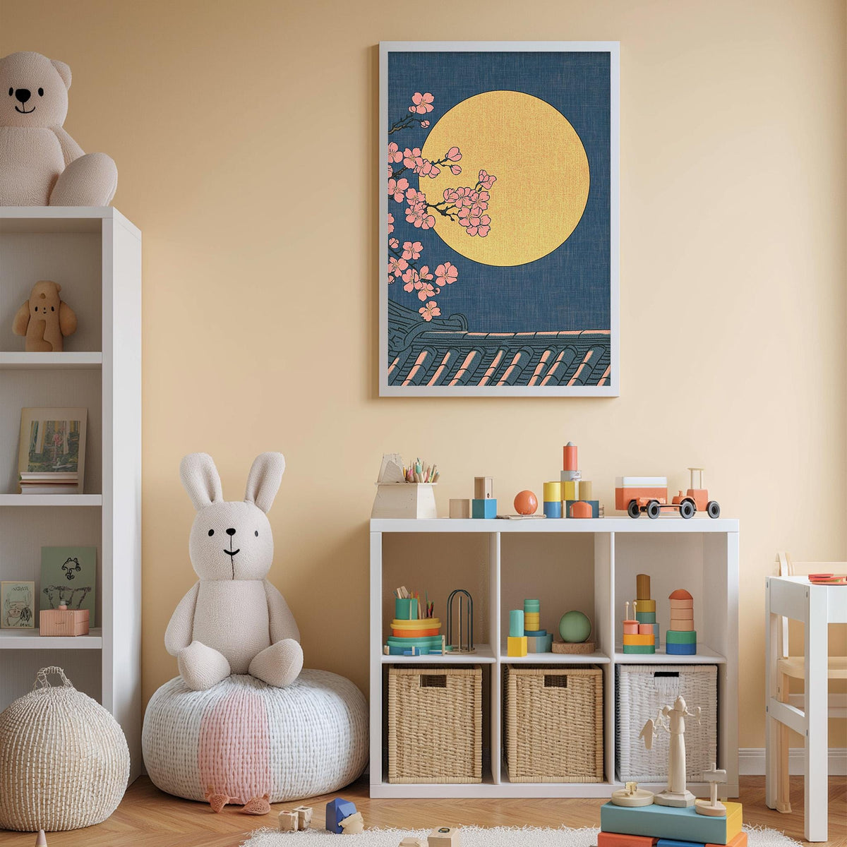 A cozy children's bedroom with a large stuffed bunny, a bookshelf, and a toy chest filled with toys. The walls are painted a light peach color, and there is a framed picture of a moon and cherry blossoms hanging on the wall.
