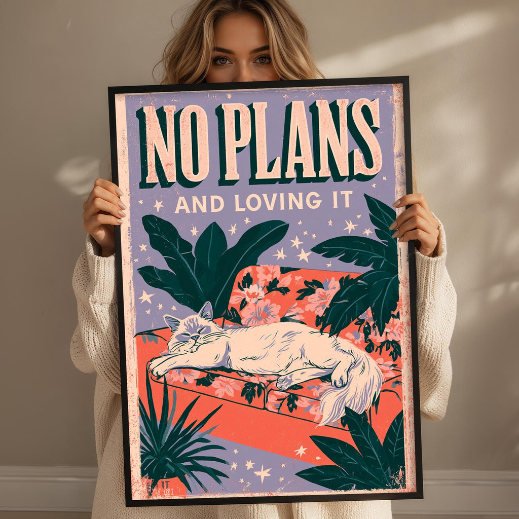 A woman holding a framed poster with a cat and tropical plants on it.