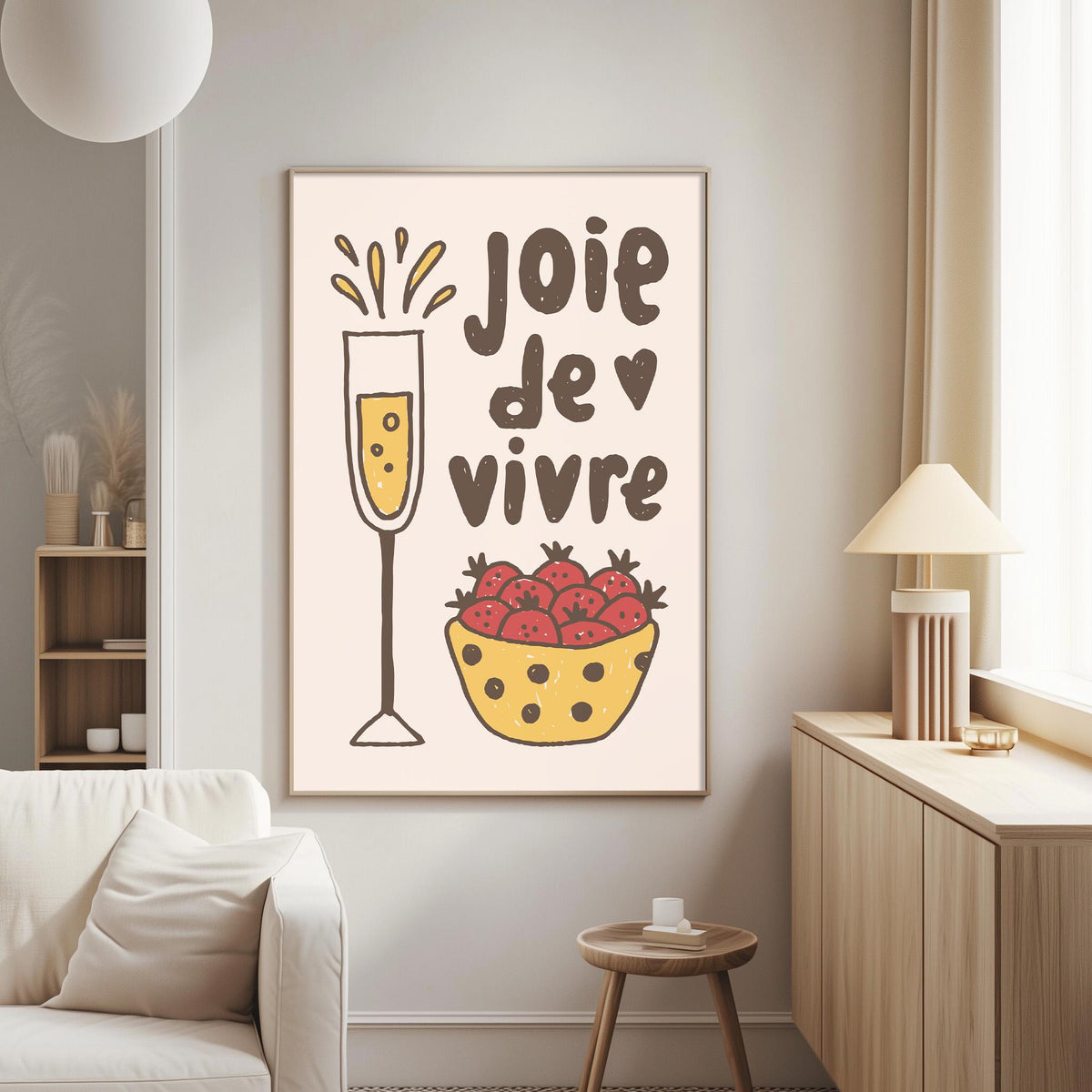 a living room with a white couch, a wooden side table, and a framed poster on the wall. The poster has a drawing of a glass of champagne and a bowl of strawberries, along with the text "JOIE DE VIVRE" which means "Happy Vivid" in French.