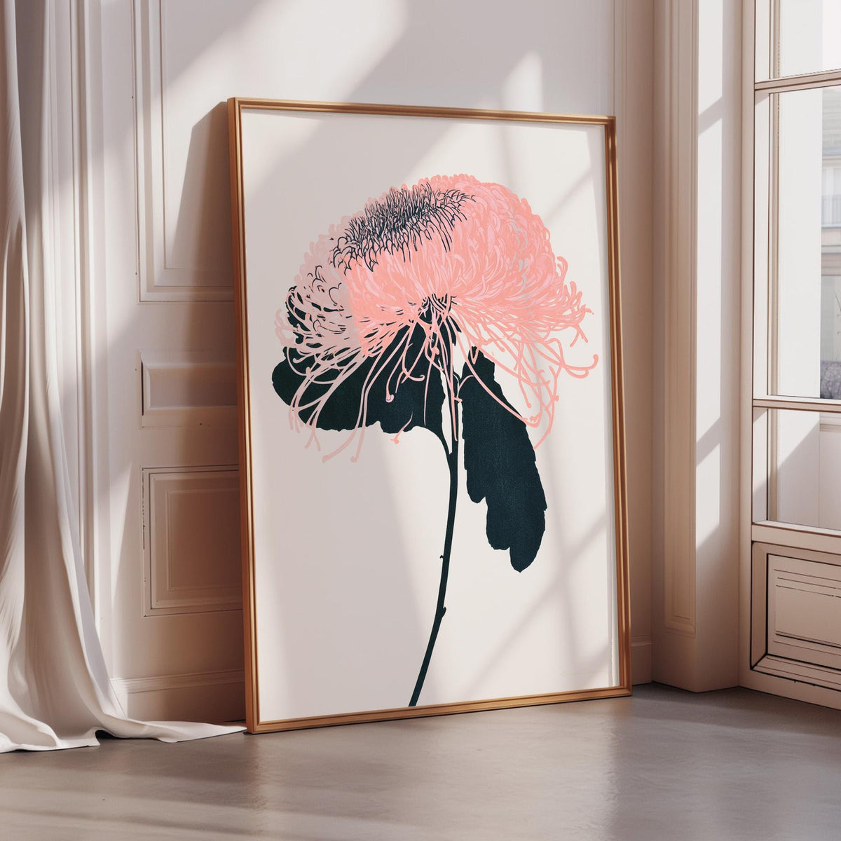 A framed print of a pink flower with black petals is displayed on a white wall in a room with a window.