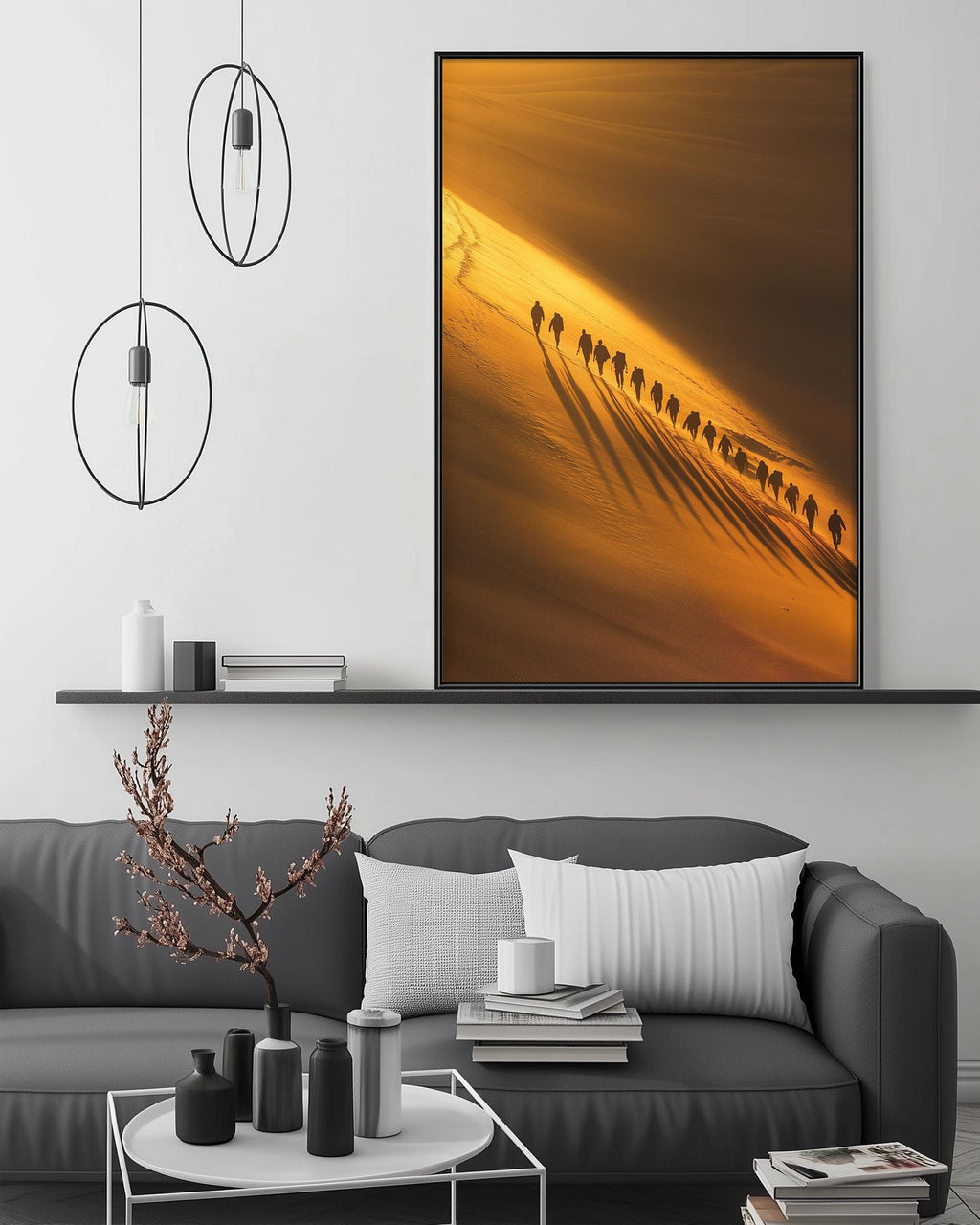 a modern living room with a gray sofa, a coffee table, and a large framed photograph of a desert landscape with a line of people walking across it.