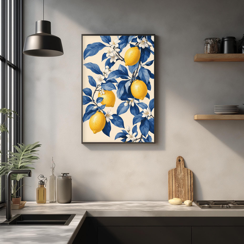a kitchen counter with a framed print of a lemon tree on the wall above it. The print has a blue and white color scheme and depicts three lemons on the tree. The kitchen counter also has various items such as a cutting board, a soap dispenser, and a bottle.