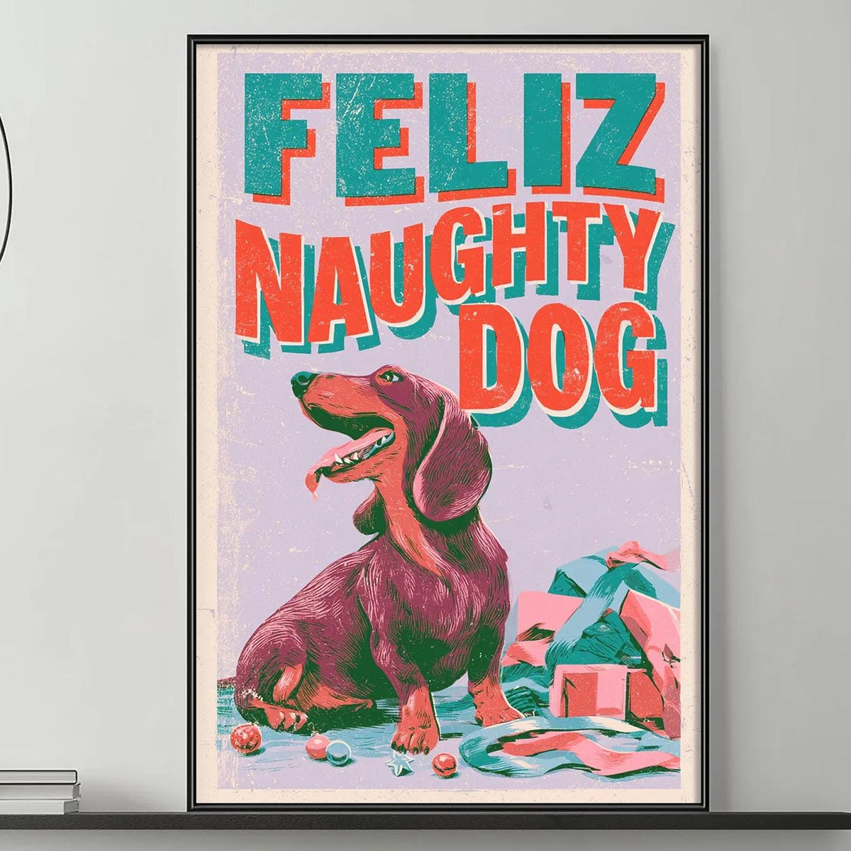 a large framed poster of a dog with the text "Feliz Naughty Dog" on it, hanging on a wall above a gray couch in a living room setting.