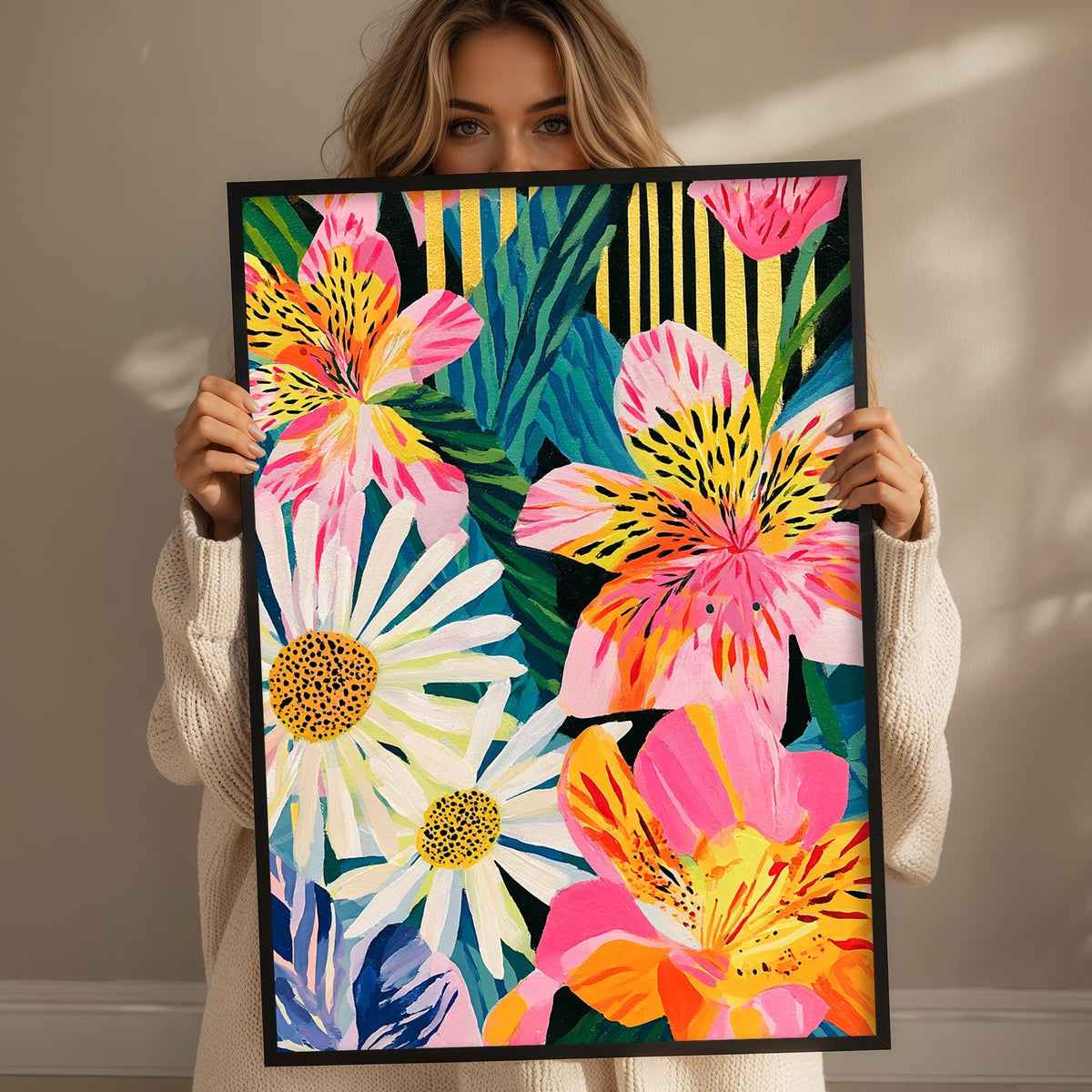 A woman holds up a framed painting of a vibrant, colorful floral design.