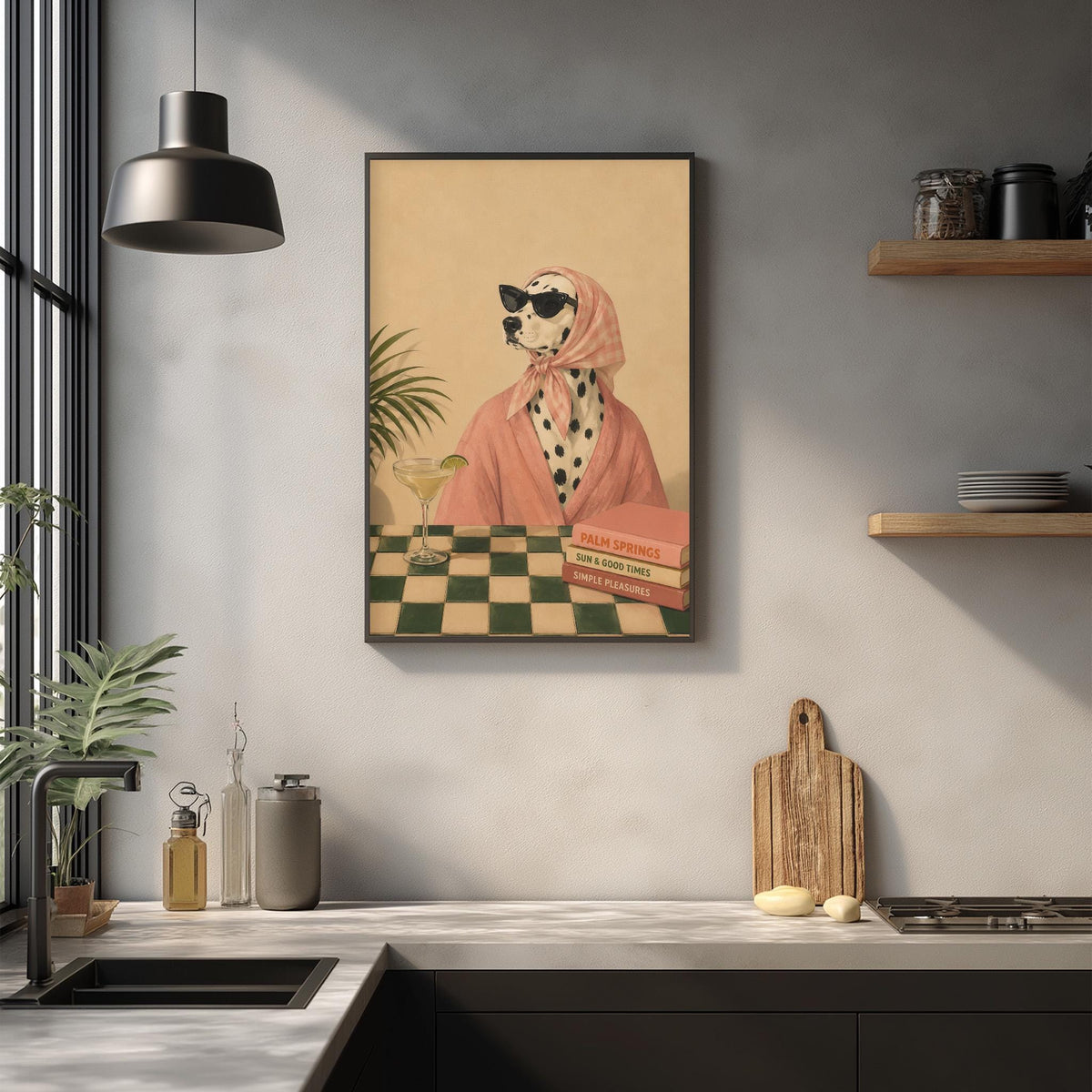 a framed illustration of a Dalmatian dog wearing a pink scarf and sunglasses, sitting at a table with a drink and a book, in a kitchen setting with a checkered tablecloth and various kitchen items on the counter.