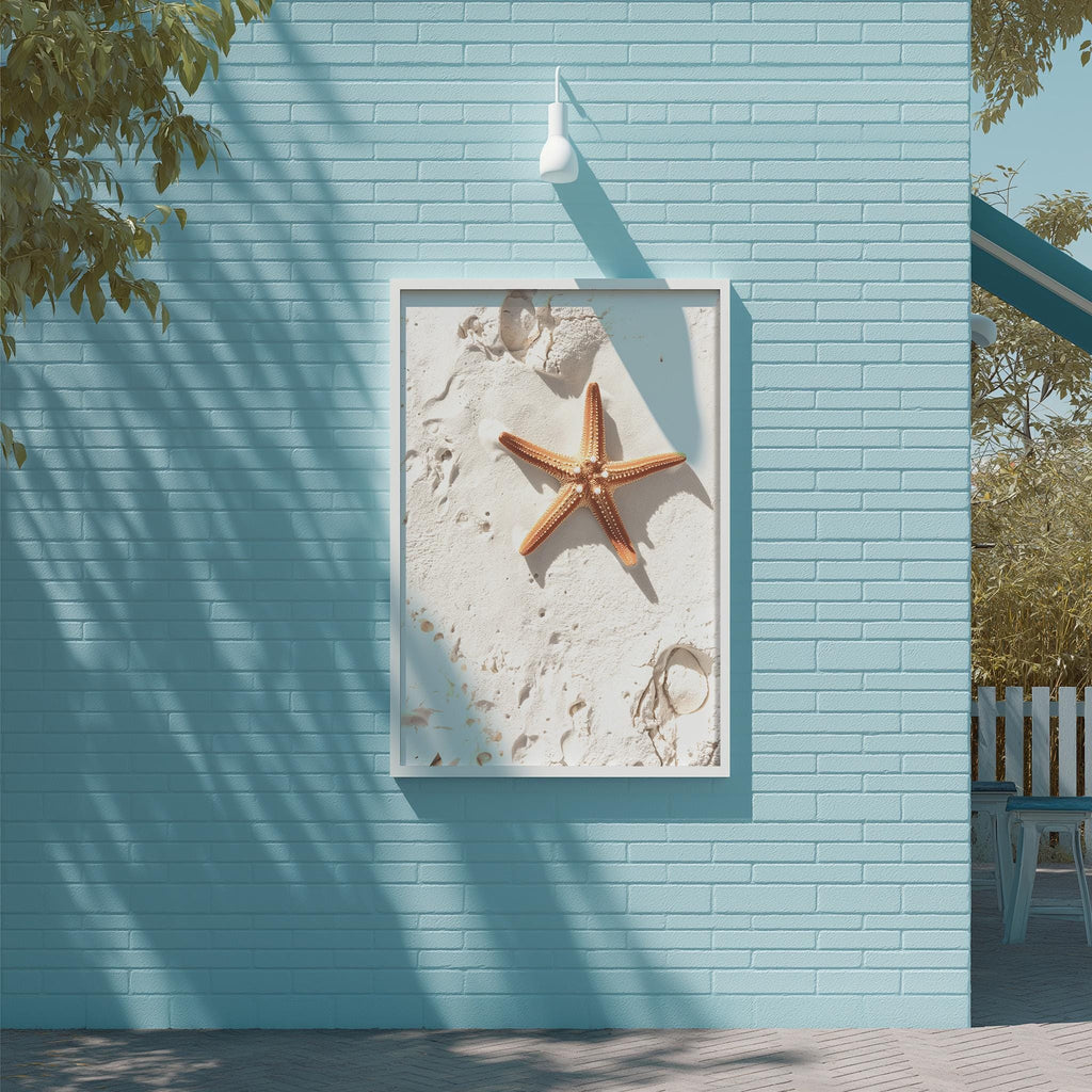 a blue wall with a framed picture of a starfish and sand on it, creating a beach-themed atmosphere.