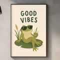 a framed poster of a frog sitting on a lily pad, wearing sunglasses and holding a drink, with the text "GOOD VIBES" above it. The poster is displayed on a wall above a kitchen counter with various kitchen items such as a cutting board, a bottle, and a plant.