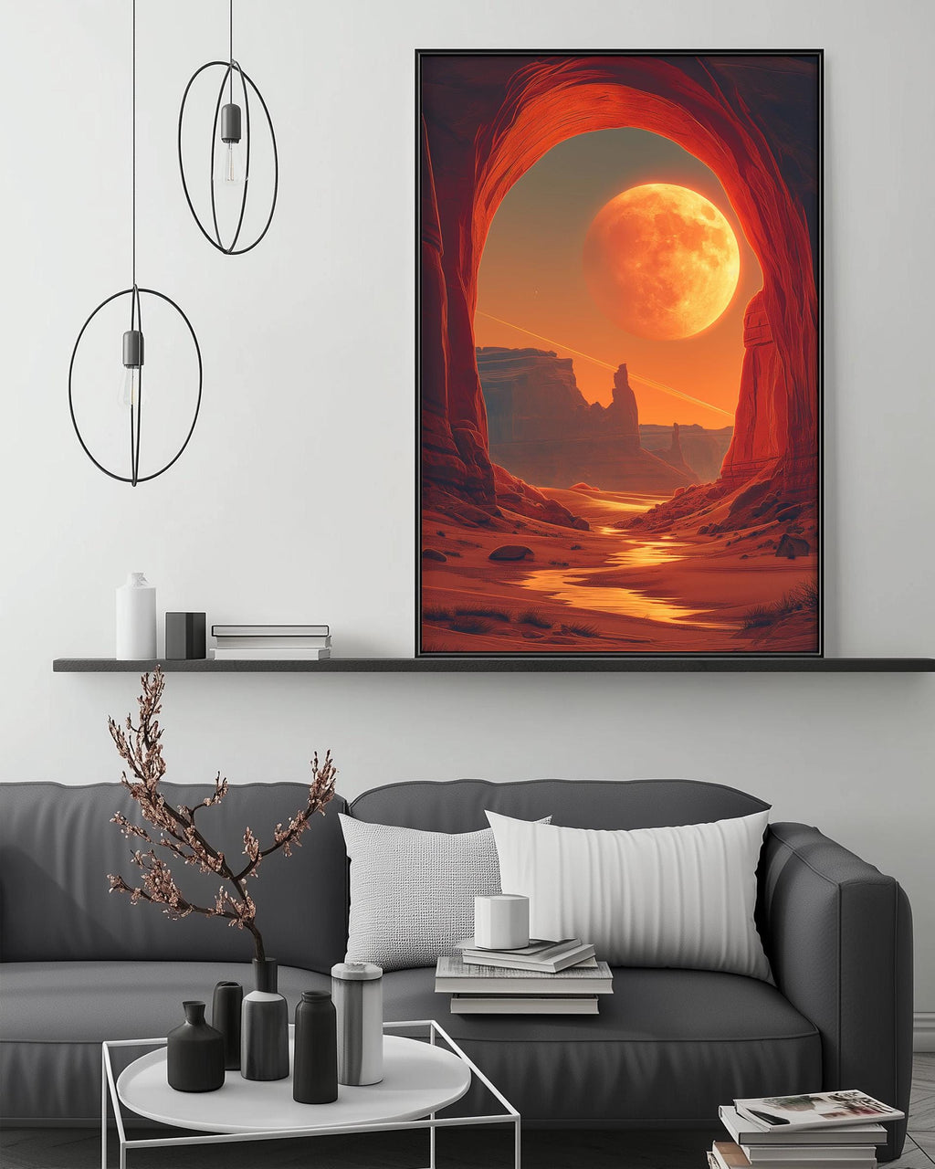 a large, vibrant painting of a desert landscape with a large, glowing moon in the sky. The painting is hanging on a wall above a gray couch, which is positioned in front of a coffee table. The room has a minimalist and modern design, with a few decorative items such as a potted plant, vases, and books on the coffee table.