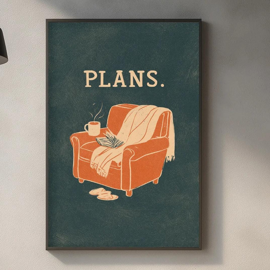 a kitchen counter with various items such as a cutting board, a plant, and a coffee mug. Above the counter, there is a framed poster with an illustration of a chair and the text "PLANS."