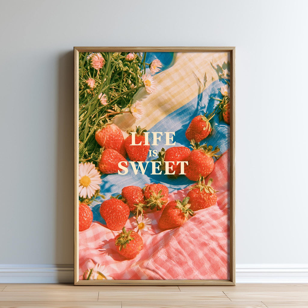 The image is a framed poster with a vibrant display of fresh strawberries and flowers, accompanied by the text "LIFE IS SWEET" in a playful and colorful style.